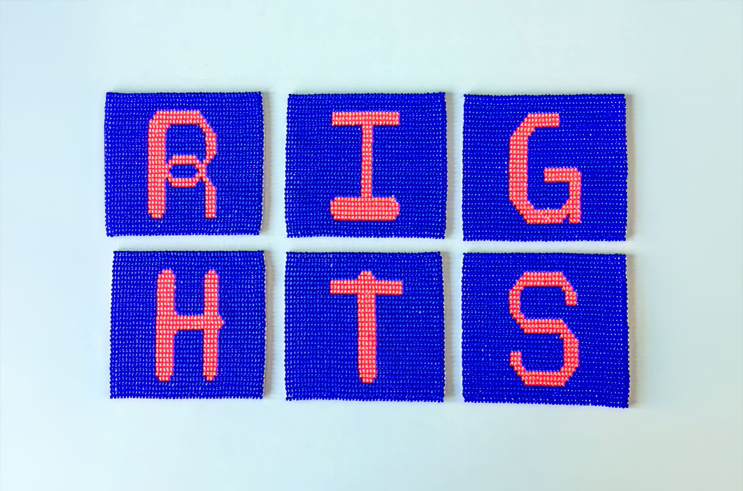 Six square panels with beaded blue backgrounds and large, orange beaded letters on each, spelling 