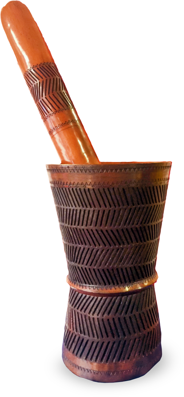 A tall, wooden mortar and pestle with intricate, geometric carvings in a zigzag pattern. The mortar is cylindrical and slightly flared at the base and rim. The pestle is smooth and rounded, both are polished and reddish-brown in colour.