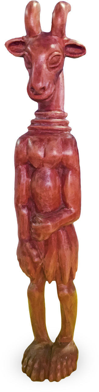 Wooden sculpture of an anthropomorphic goat standing upright with a calm expression, large ears, and curved horns. The figure has human-like arms, hands folded at the front, and hoofed feet. The surface is smooth and reddish-brown in colour.