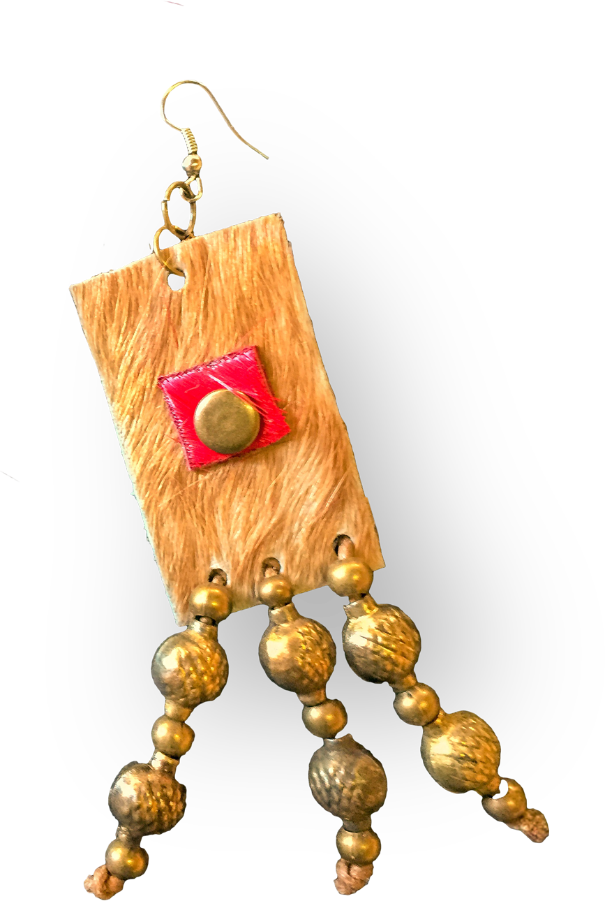A handmade earring with a rectangular, tan textured base, a small red square and brass stud in the centre, featuring three strands of round, textured golden beads hanging below. The earring has a hook for wearing. The background is black.