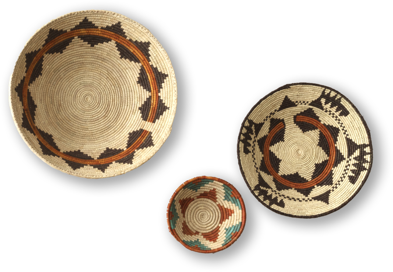 Three woven baskets are displayed against a black background. Each features intricate geometric patterns in earthy tones of brown, black, beige, and some greenish blue, with the two larger baskets showing star-like and zigzag designs, and the smallest basket having a colourful rim.