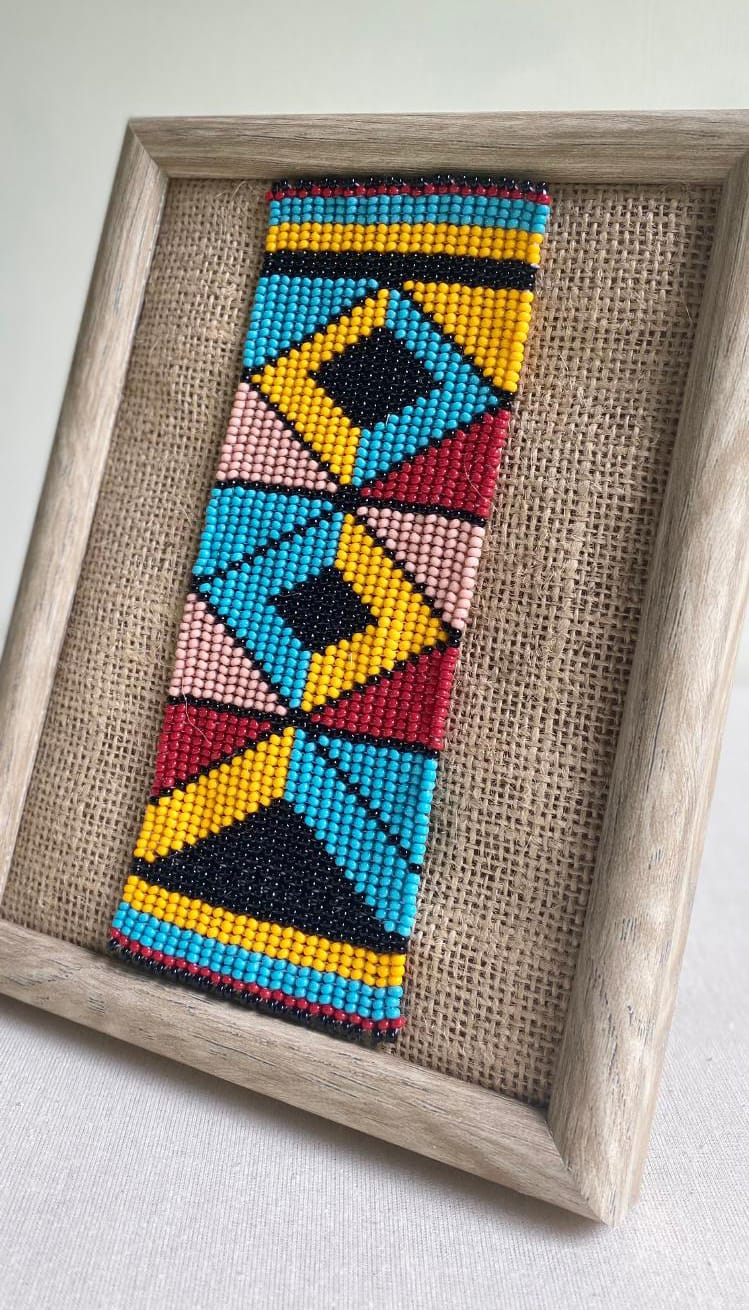 A framed beaded artwork titled 